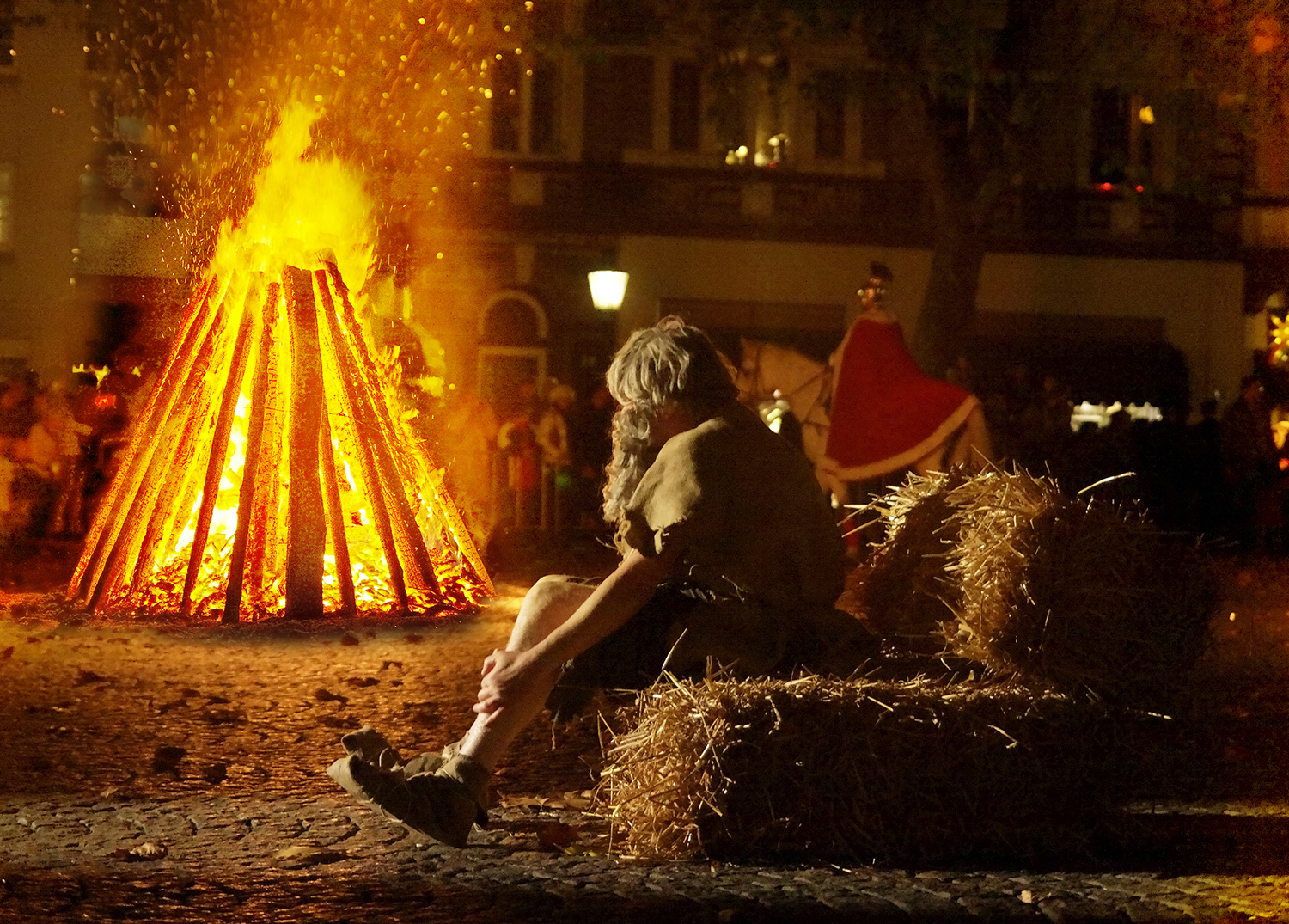 Spielszene: Am großen Feuer wartet der arme Mann auf den Sankt Martin.