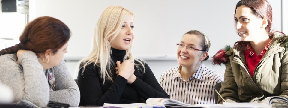 Vier Menschen an einem Tisch unterhalten sich.