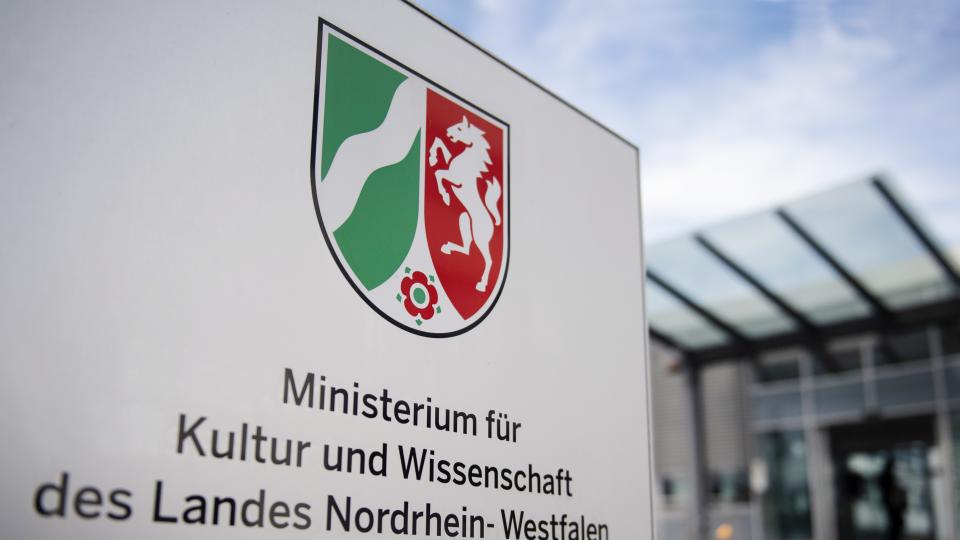 Schild vor dem Eingang des Ministeriums mit NRW-Landeswappen und der Aufschrift "Ministerium für Kultur und Wissenschaft des Landes Nordrhein-Westfalen"