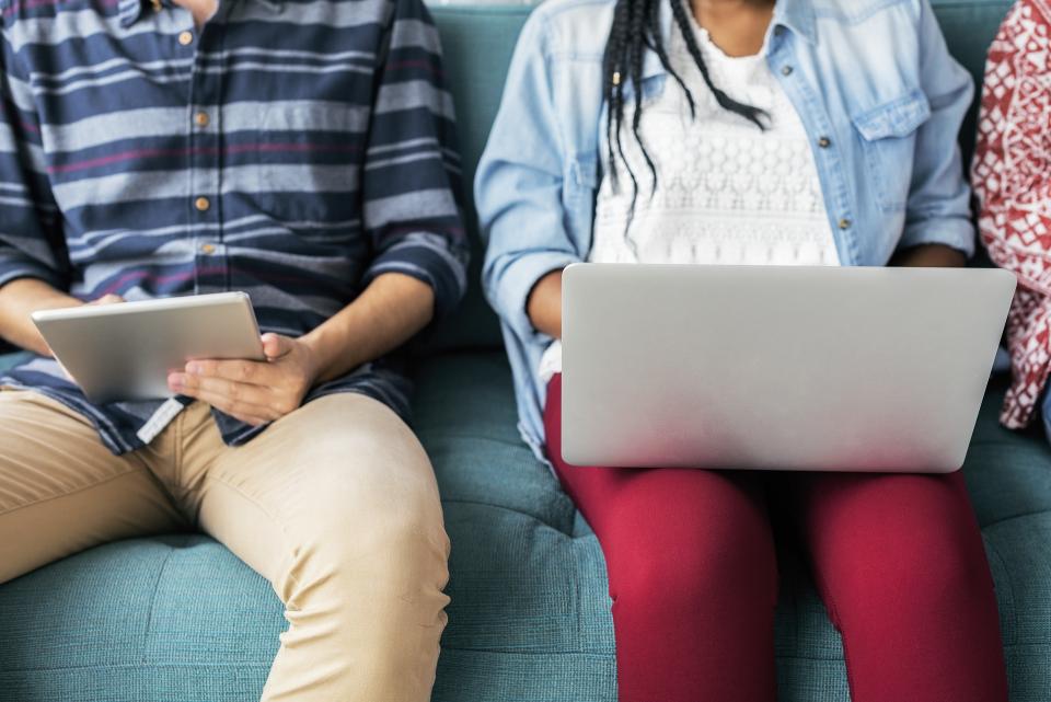 Zwei junge Menschen arbeiten an Tablet und Computer